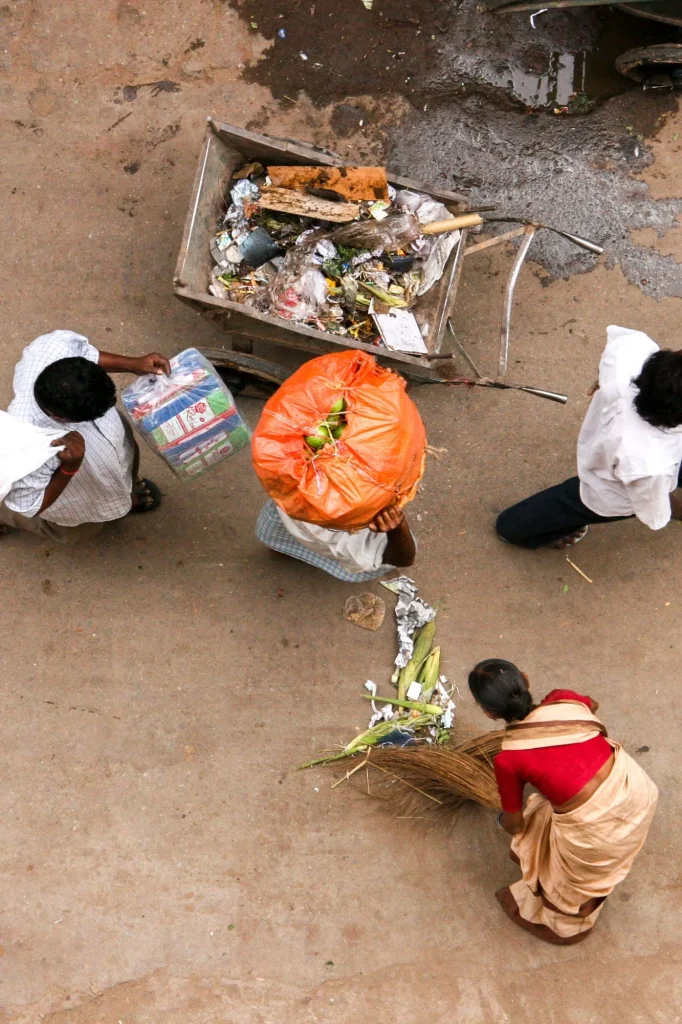 Rue indienne vue d'en haut : sacs, balayeuse en sari rouge