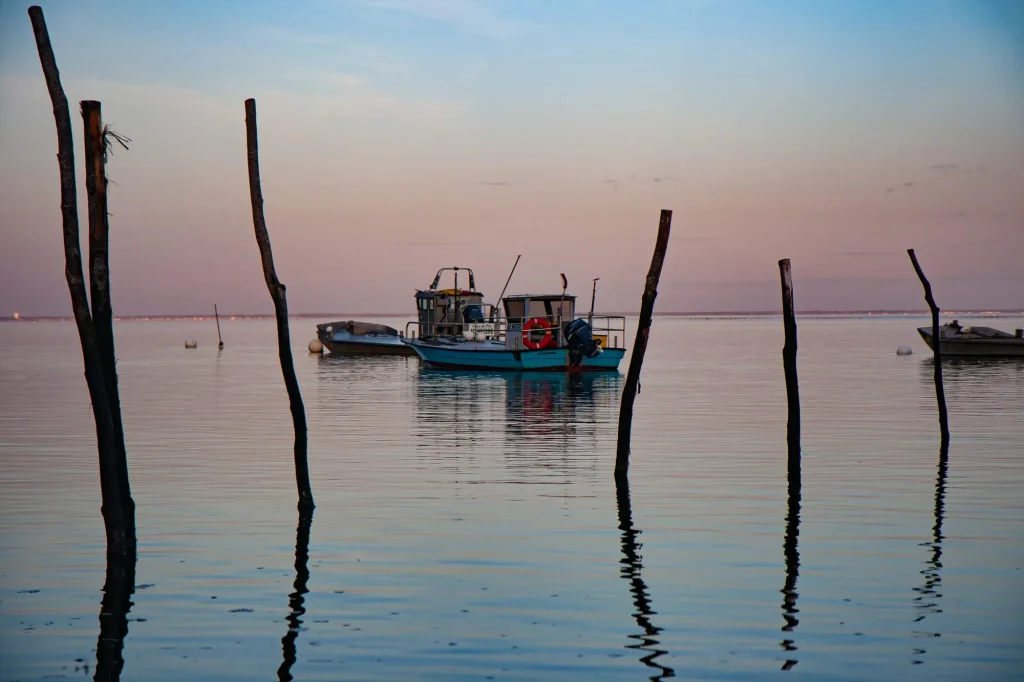 Pinasse au mouillage entre les piquets, sur le bassin d'Arcachon au crépuscule